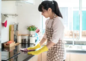Filipina housekeeper cleaning kitchen in private household